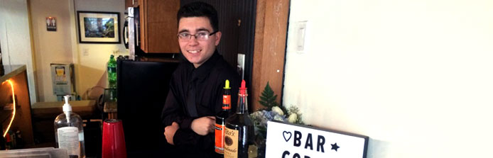 Male Bartender Smiling at the Bar