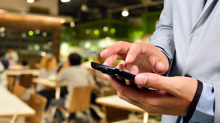 Man In Restaurant Dialing His Cell Phone